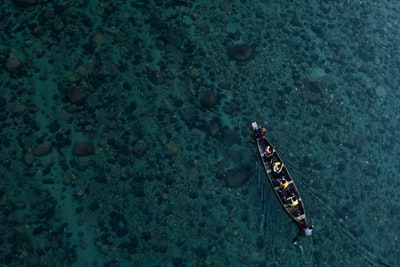 平静水面上的独木舟与人们的航拍照片